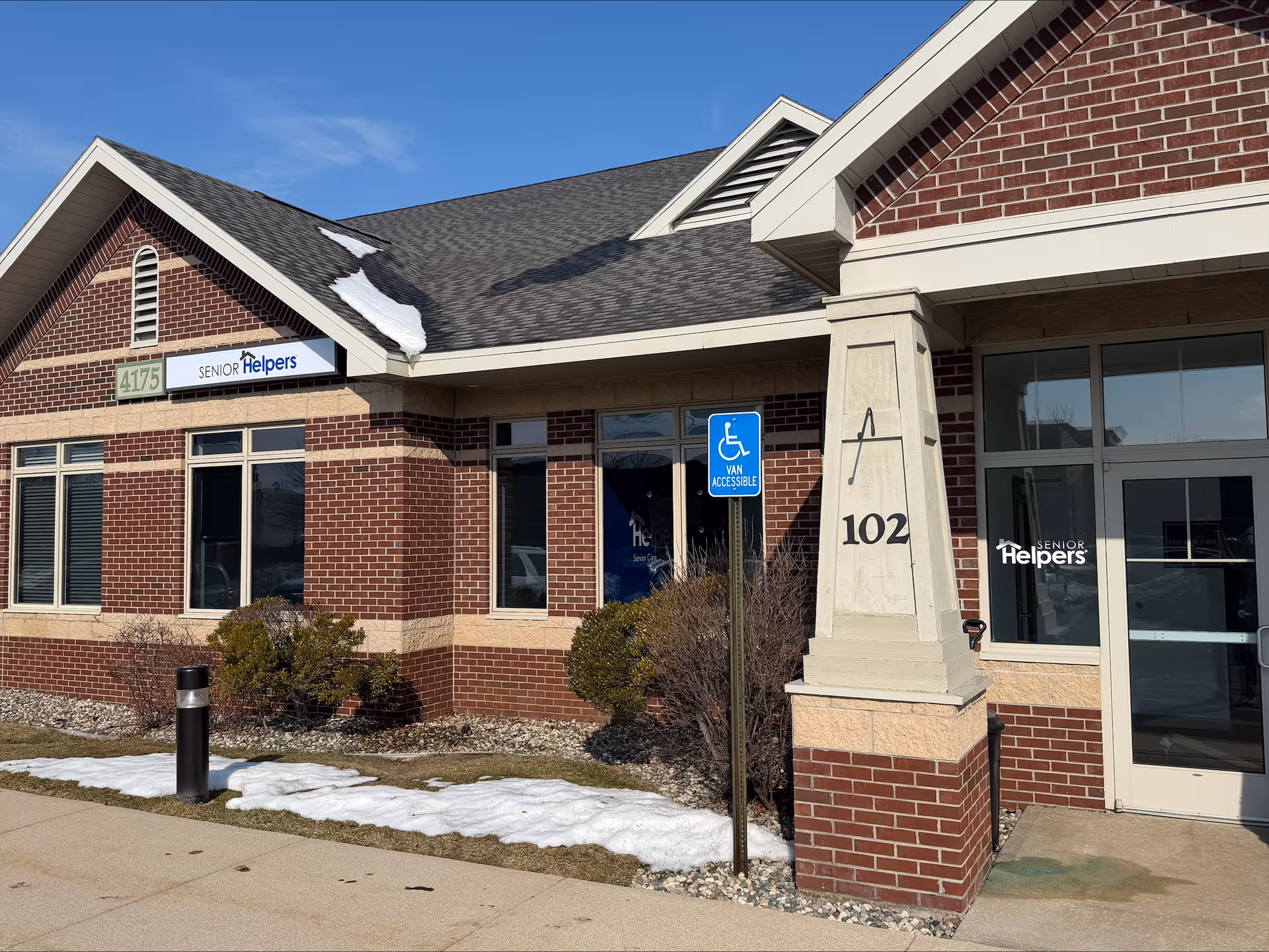 Brick exterior of a Senior Helpers facility with entrance and a handicapped sign.