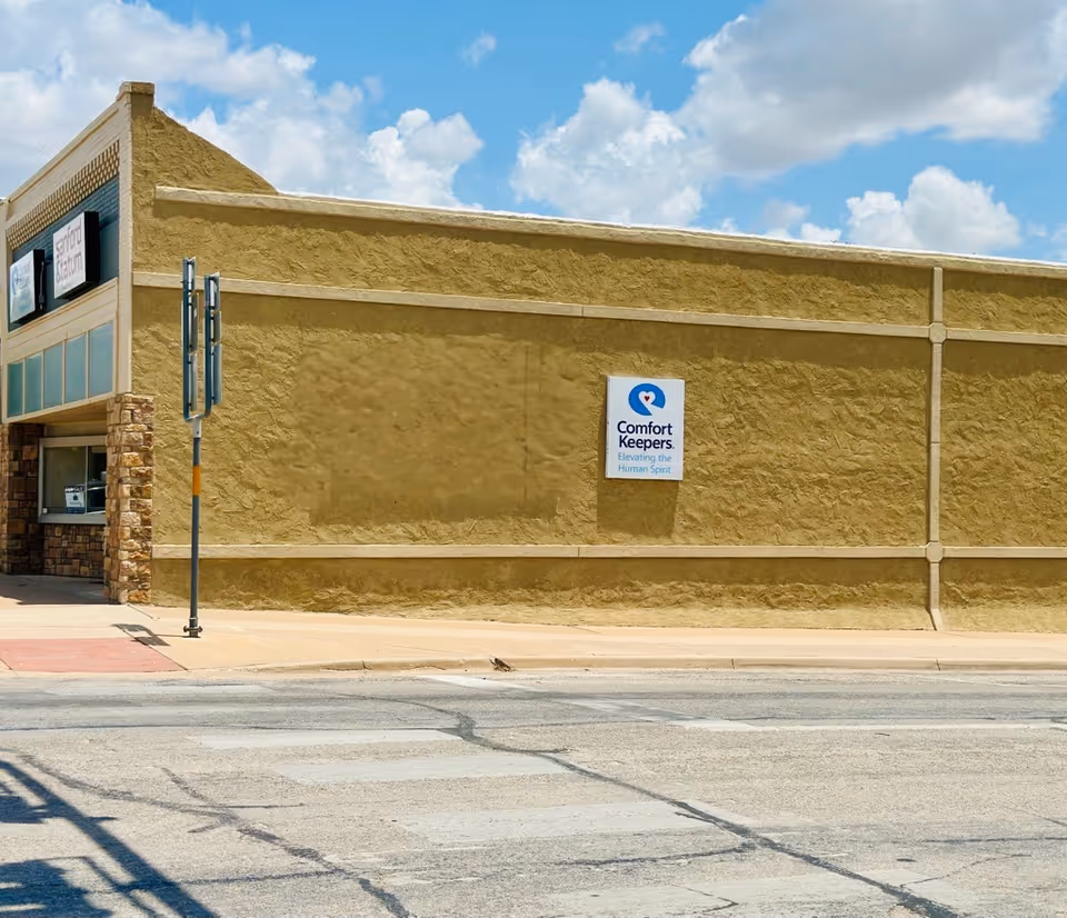 Exterior view of Comfort Keepers building with beige walls and sign.