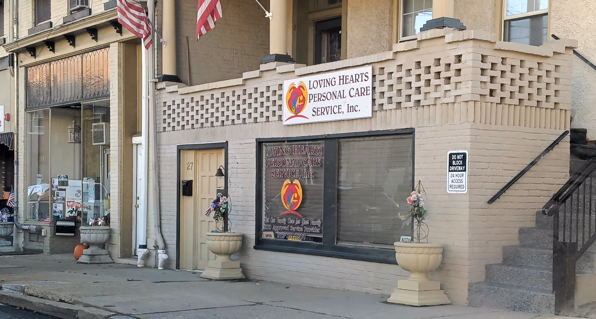 Storefront building with Loving Hearts Personal Care Service Inc sign on the street.