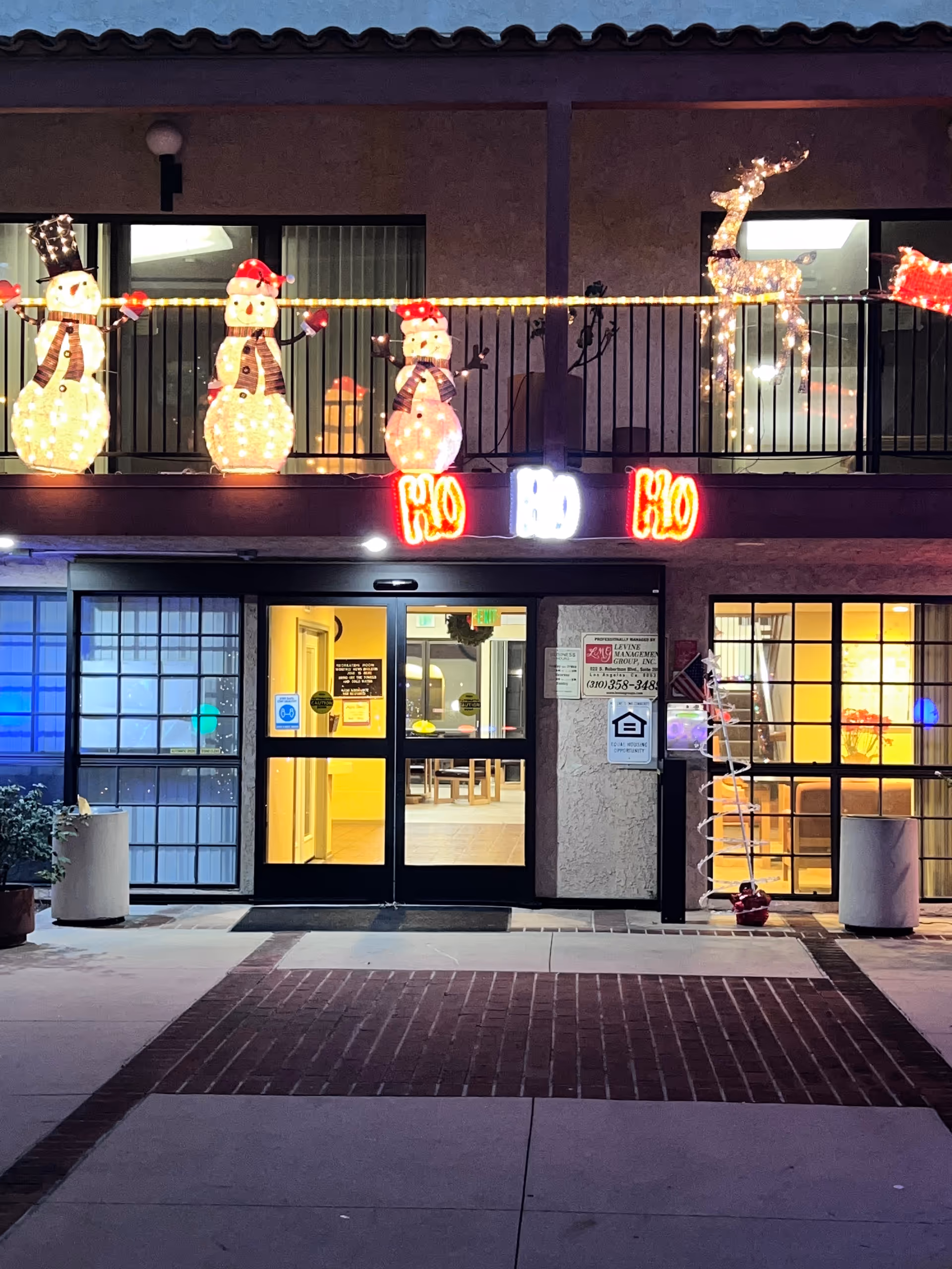 Night exterior of Canyon Terrace Senior Living with festive holiday lights above the entrance.