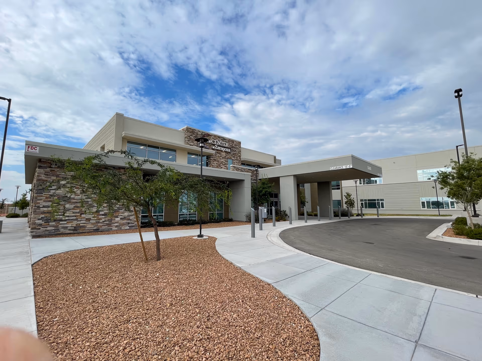 Center at Zaragoza senior living facility exterior with curved driveway and covered entrance.