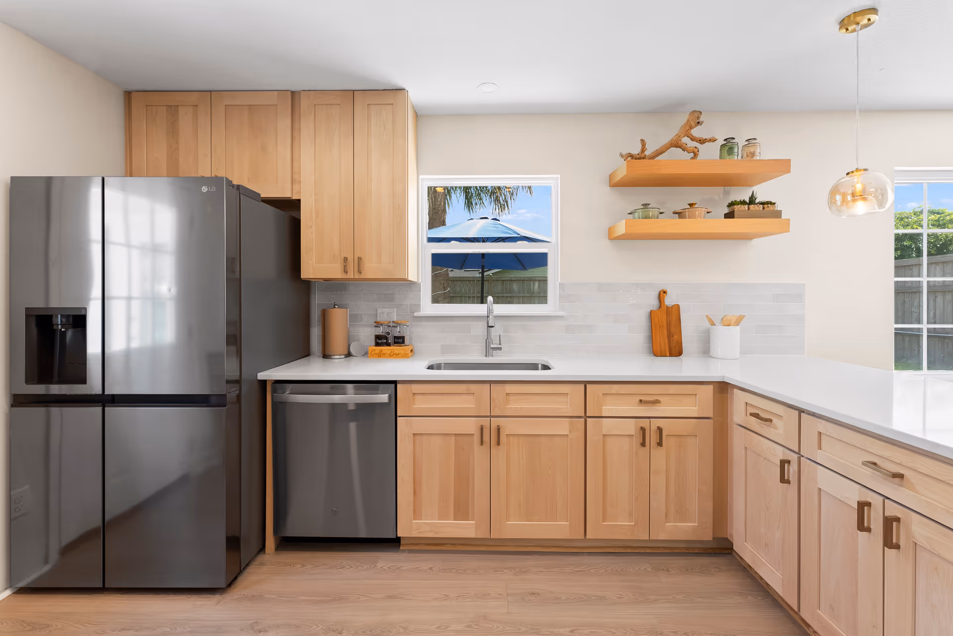 Modern kitchen with wood cabinets, stainless appliances, and a window over the sink.