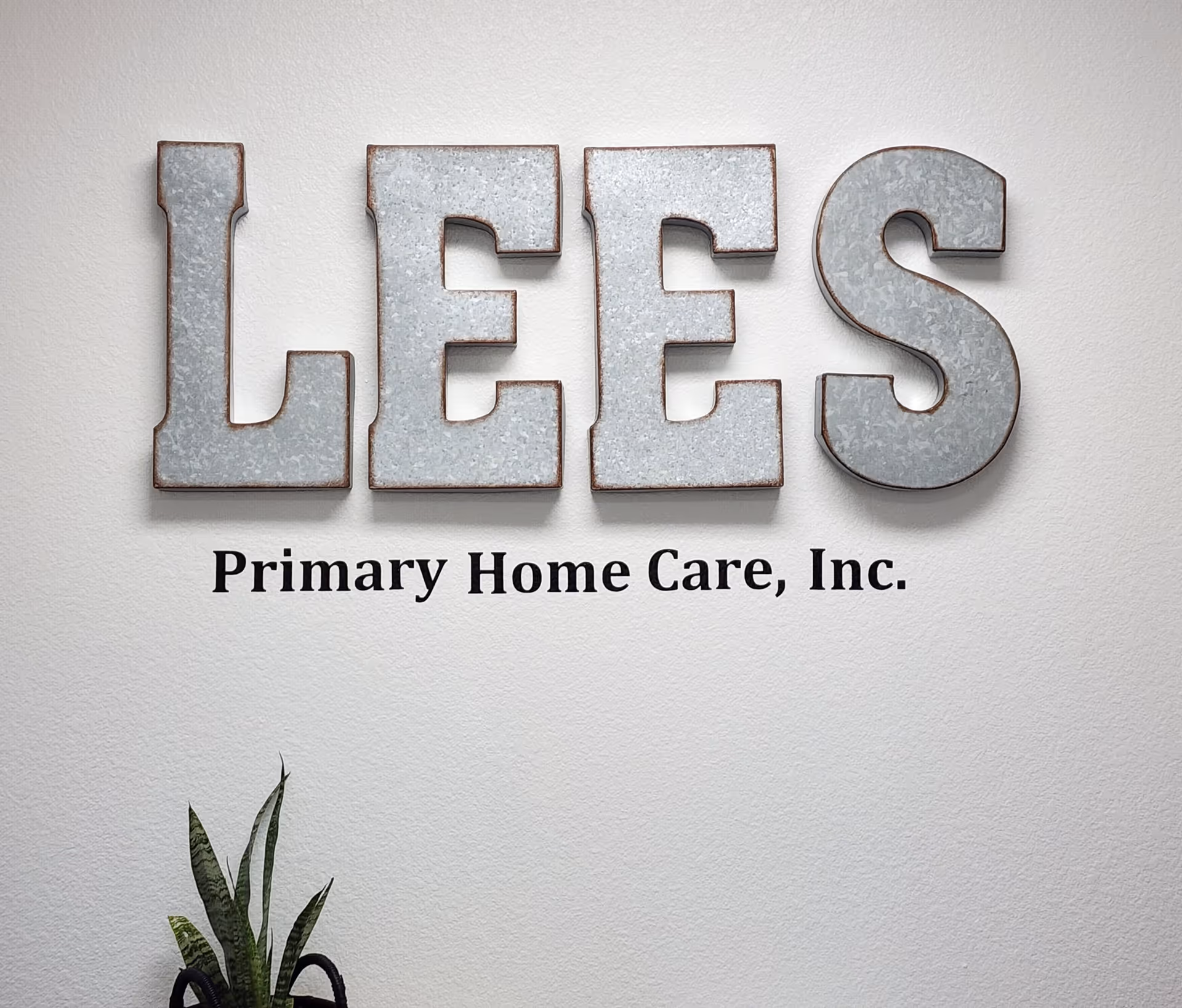 Interior wall sign reads LEES and Primary Home Care, Inc., with a plant nearby.