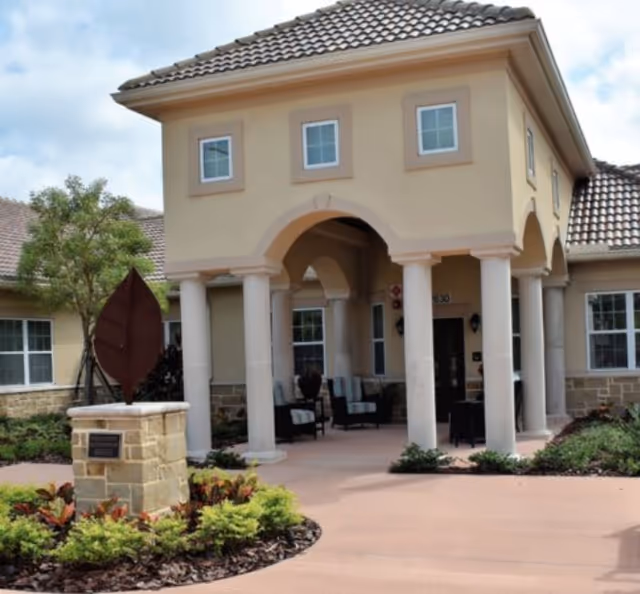 Front entrance of Liana of Sarasota with arches, columns, and outdoor seating.
