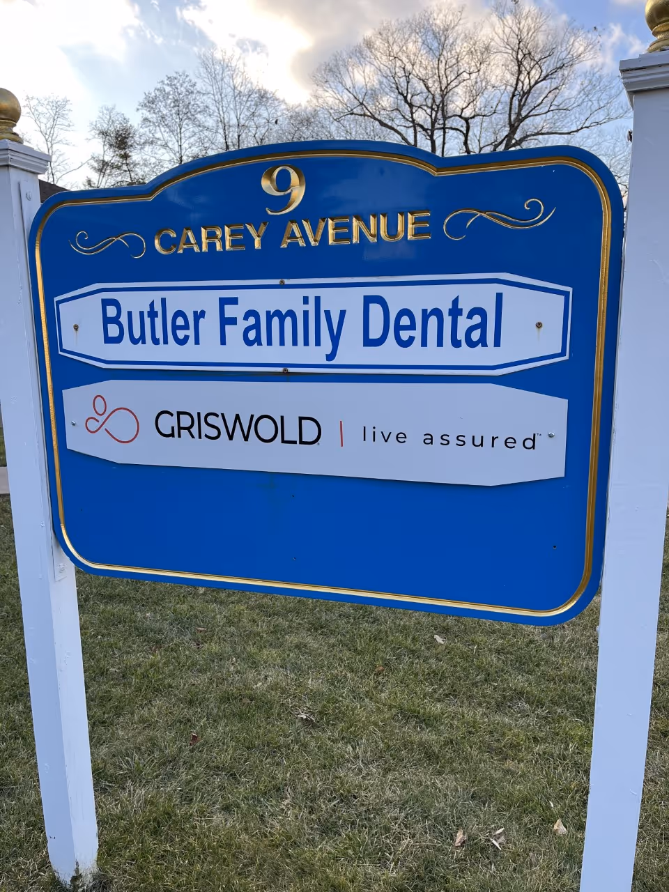 Blue outdoor sign advertising Butler Family Dental at 9 Carey Avenue.