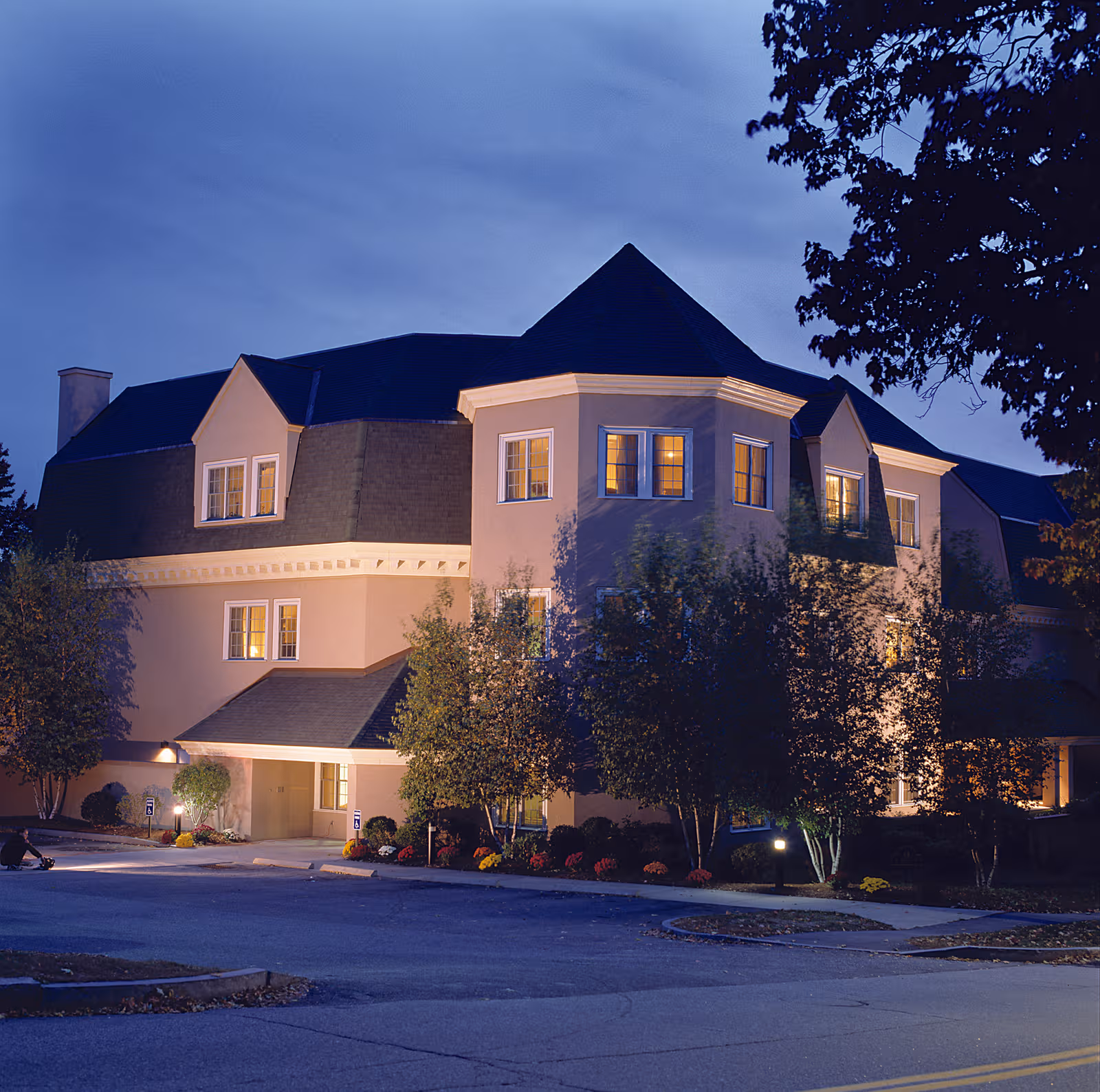 Exterior view of The Courville at Manchester at dusk with lit windows.