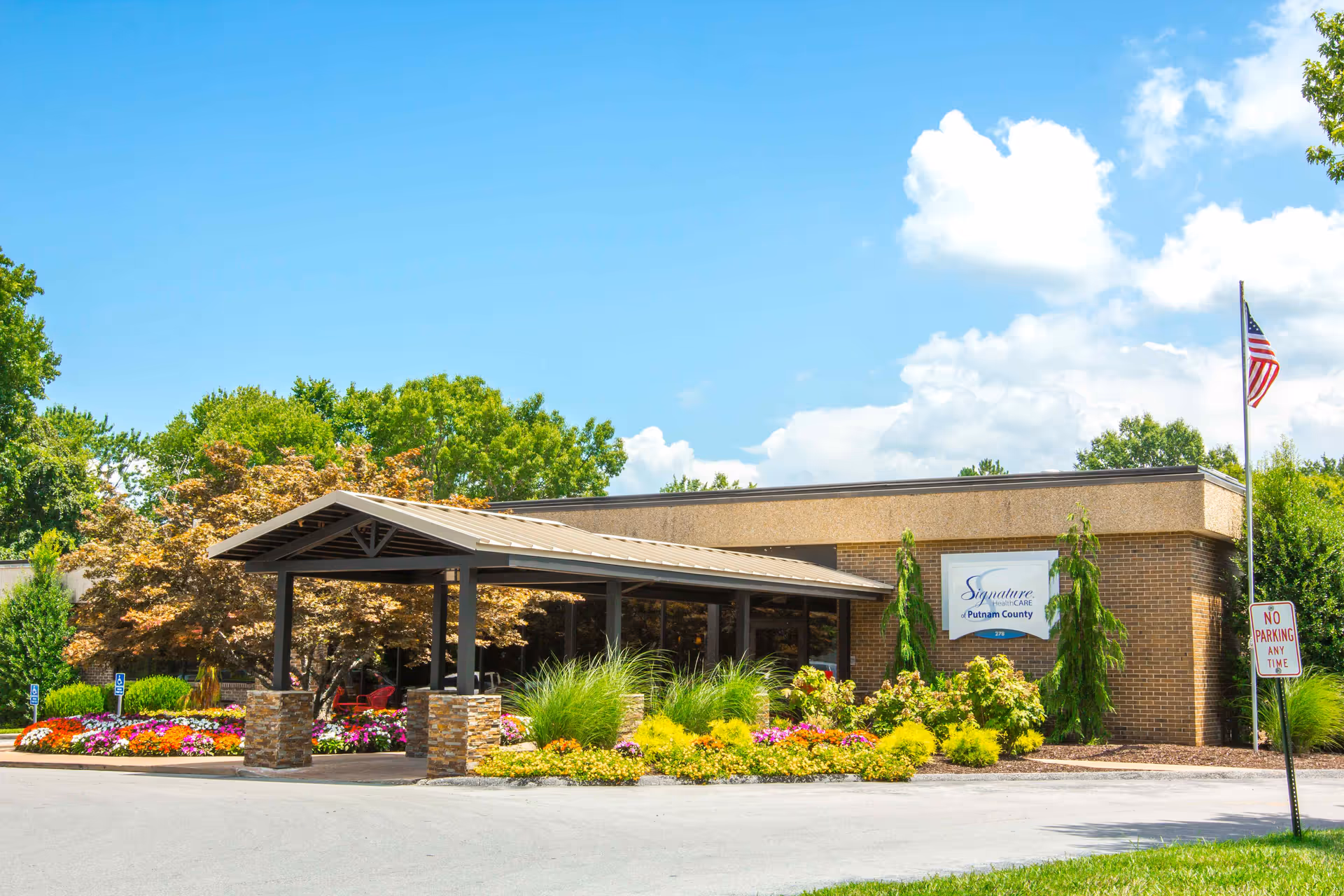 Exterior view of Signature HealthCARE of Putnam County entrance with a landscaped, colorful garden.