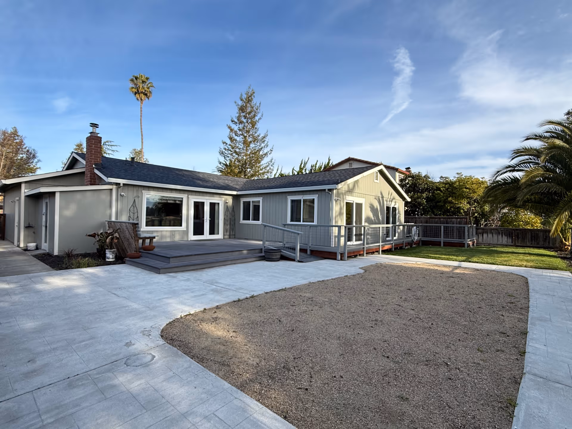 Front view of a single-story care home with deck, ramp, and yard.