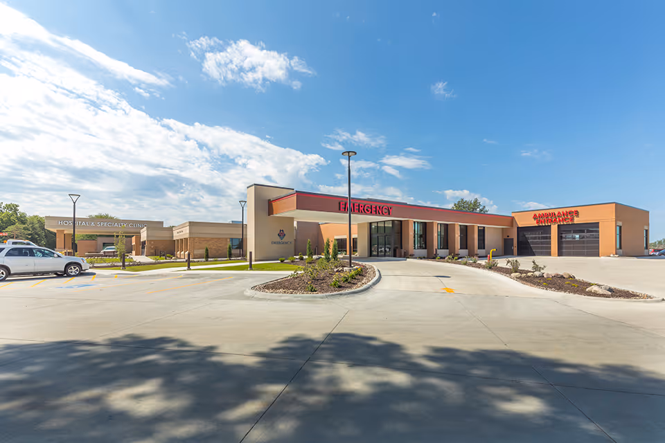 Exterior view of Burgess Health Center with emergency entrance and surrounding parking.