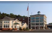 Lord Chamberlain Nursing and Rehabilitation Center campus with two buildings, flagpole, and parking.