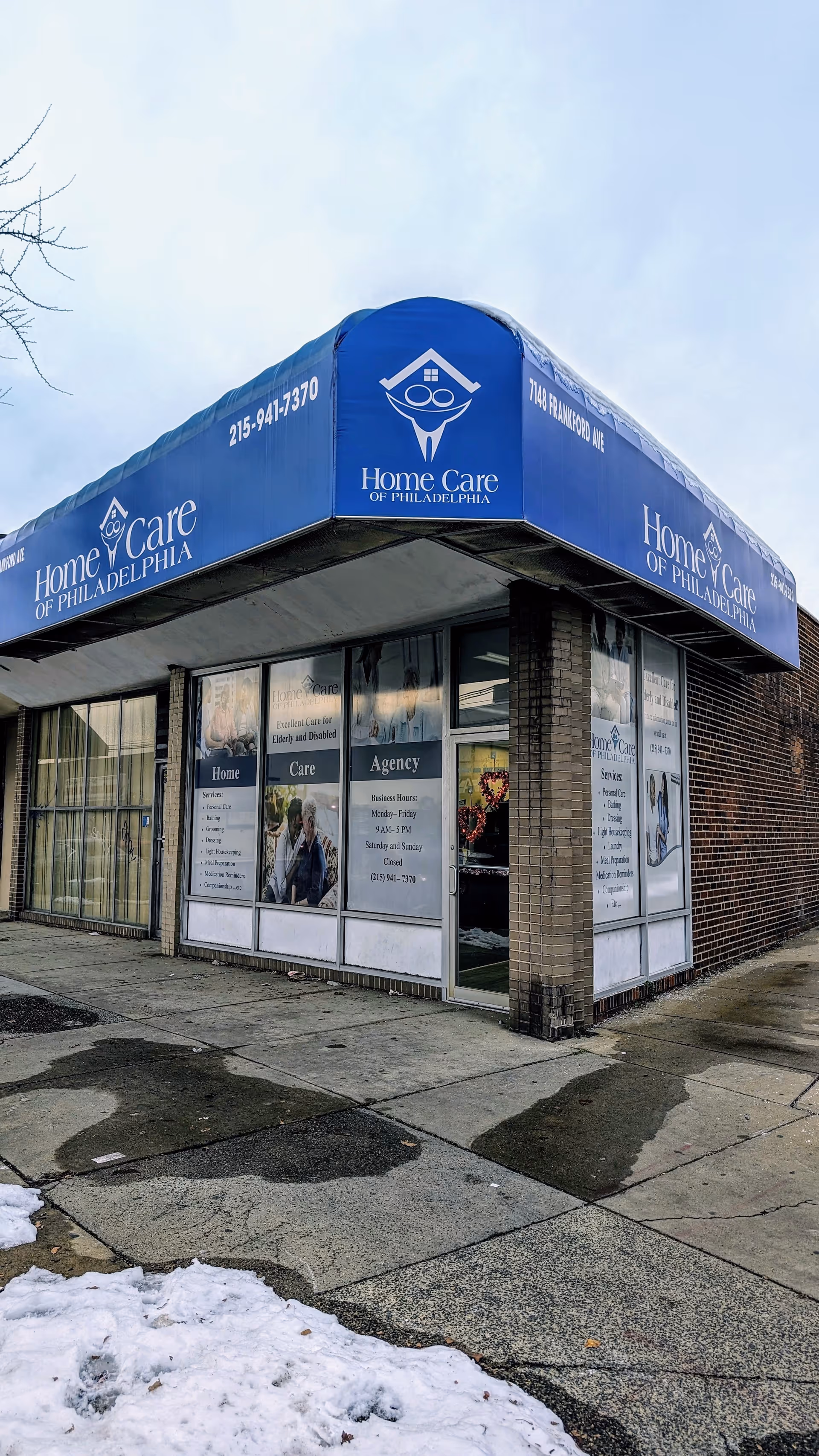 Blue awning storefront for Home Care of Philadelphia on a brick building.