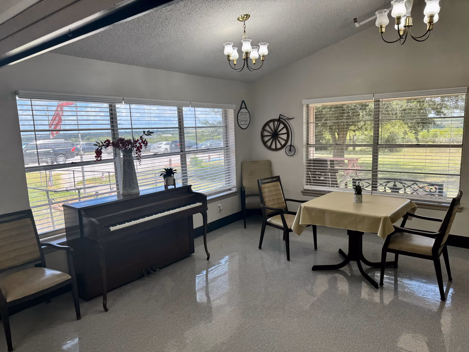 Bright dining area with piano, table, chairs, and large windows.