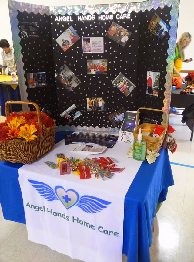 Table display for Angel Hands Home Care with photo collage backdrop.