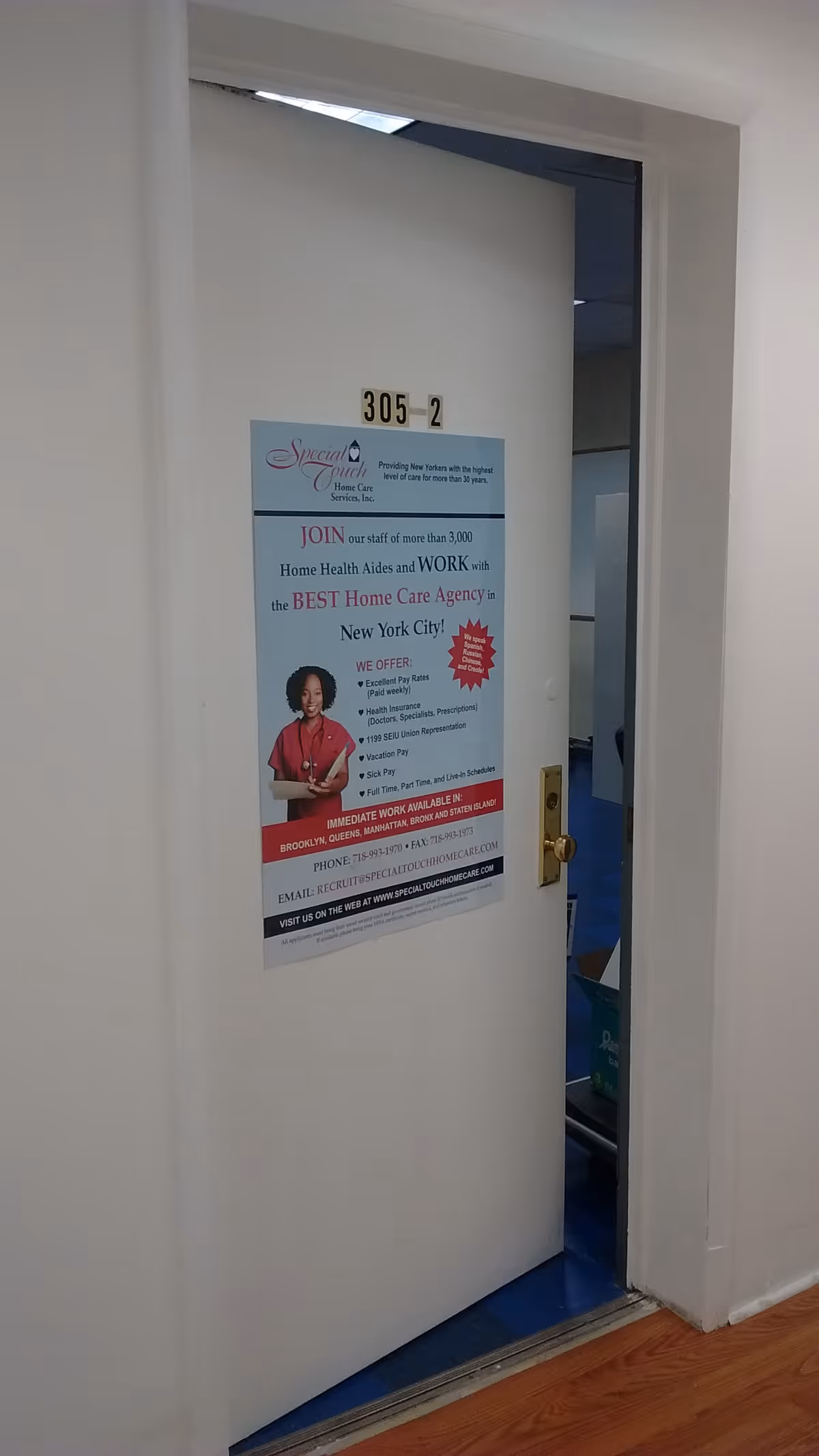 White hallway door 305-2 features a Special Touch Home Care Services poster.