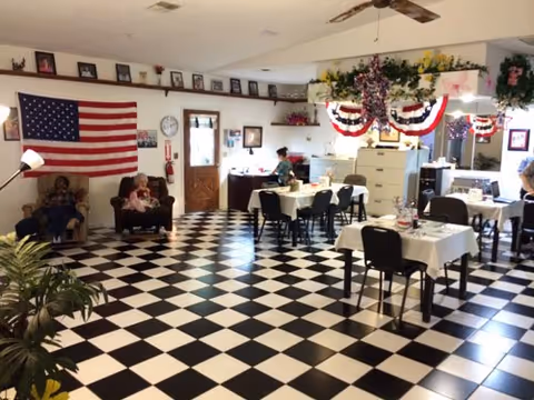 Dining room at Coventry Assisted Living with checkered floor, tables, and patriotic decorations.
