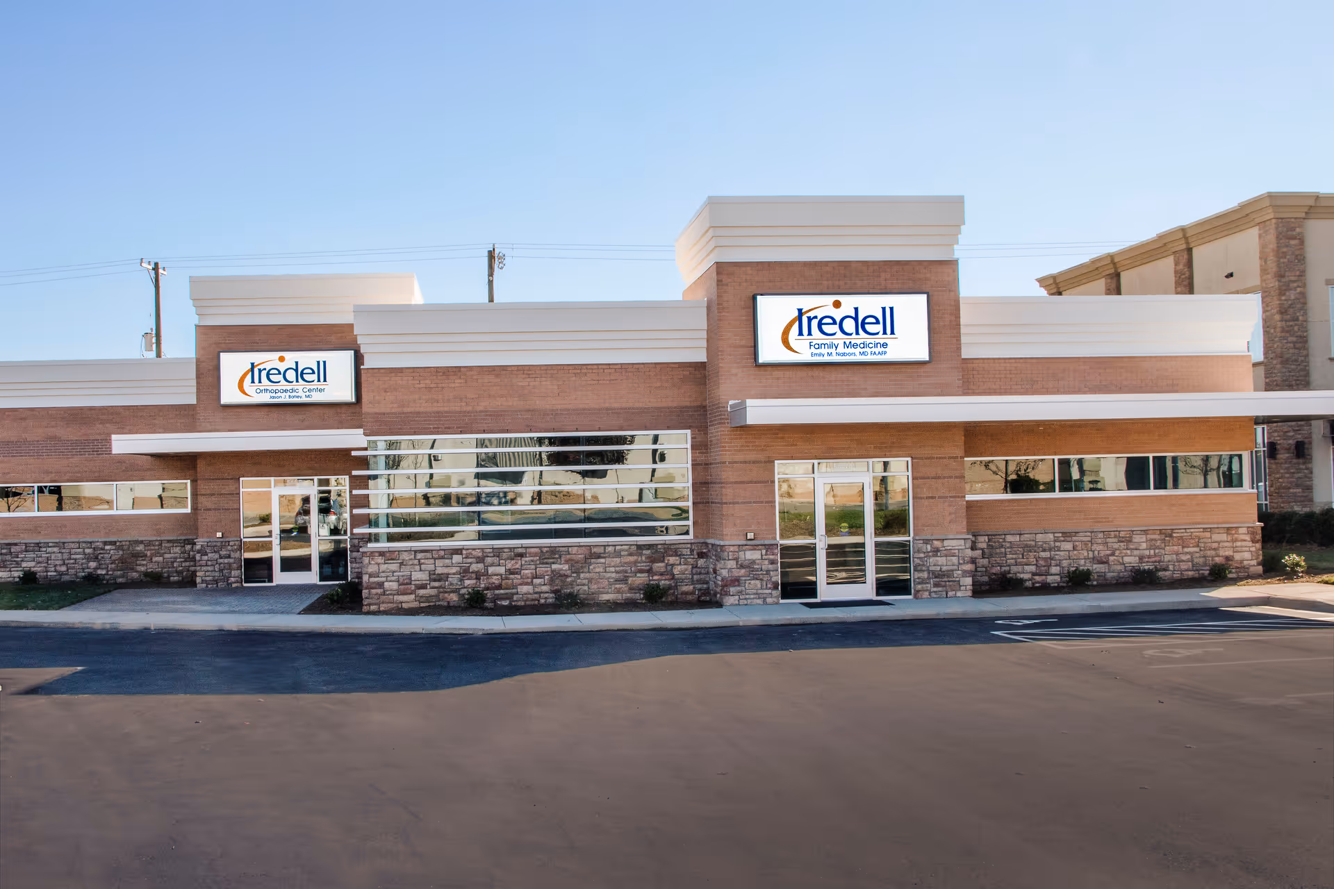 Exterior view of Iredell Health System building with brick façade and glass doors.