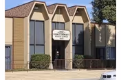 Front view of Downey Community Health Center with arched windows and a sign.