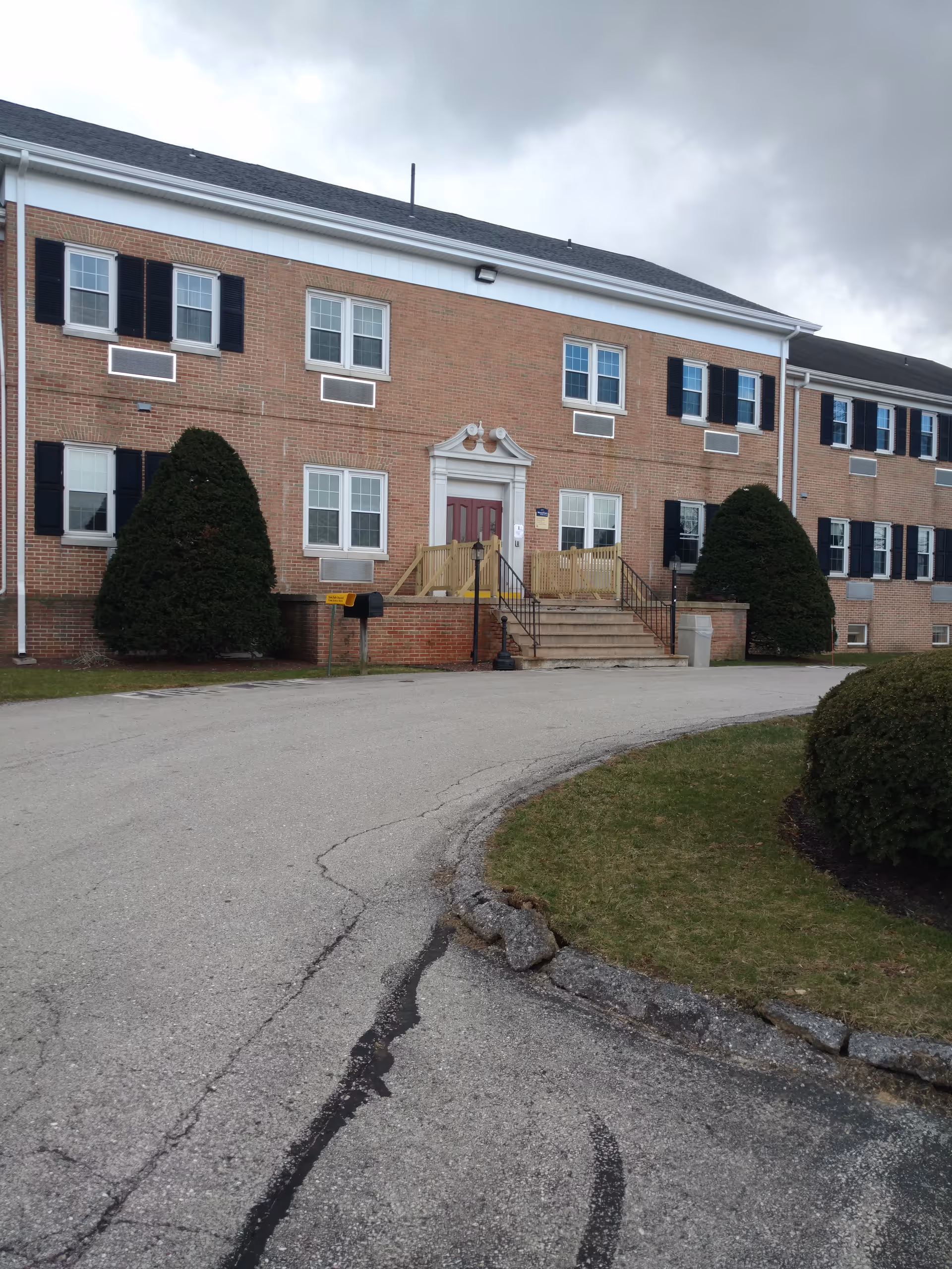 Exterior of York South Nursing & Rehab building with steps and shrubs.