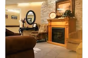 Cozy living room with a fireplace, seating, mirror, and decorative accents.