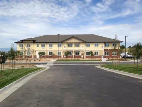 Two-story assisted living facility with a curved driveway and landscaped front lawn