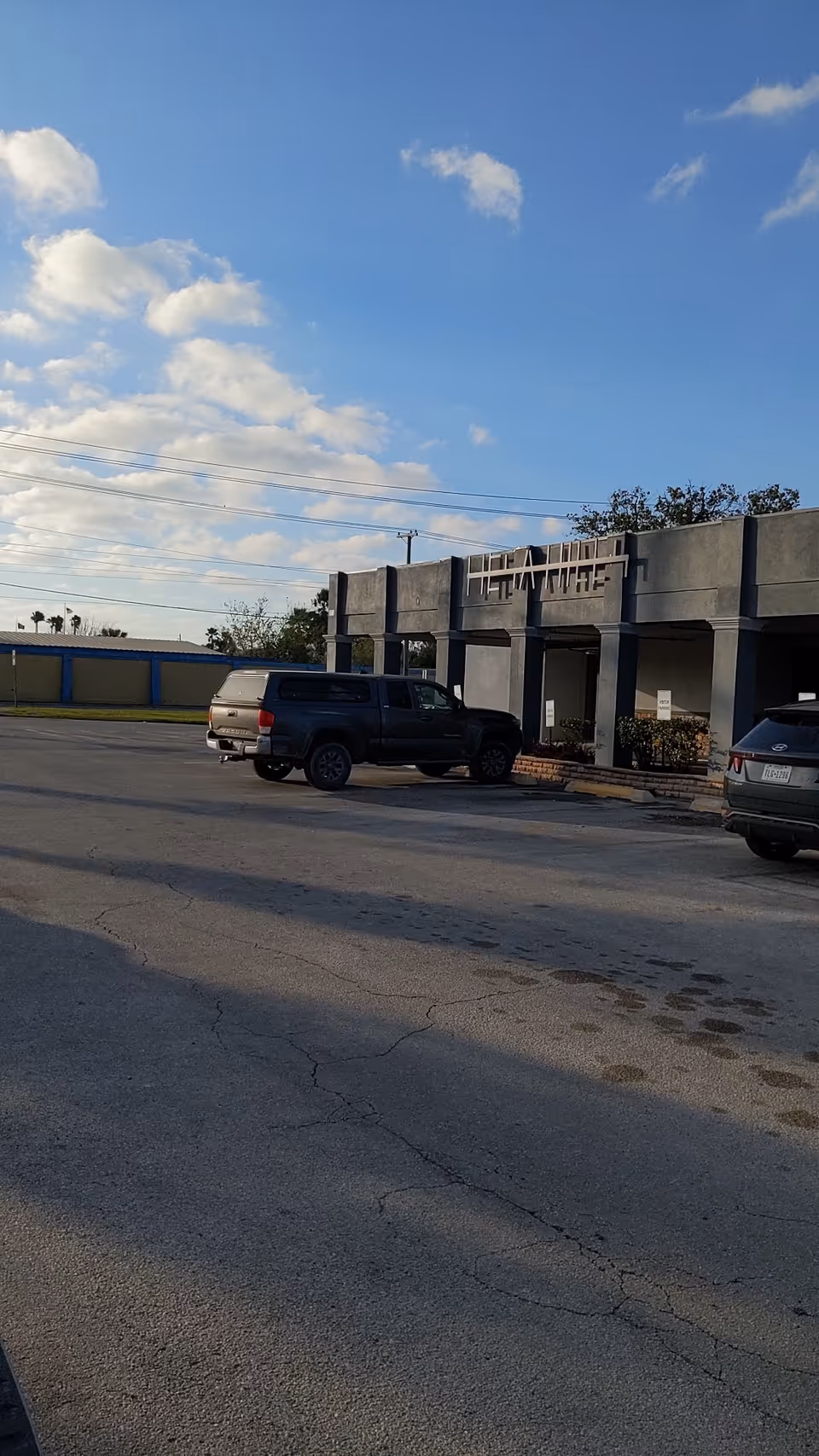 Front exterior of Valley Grande Manor with parked cars in the lot.