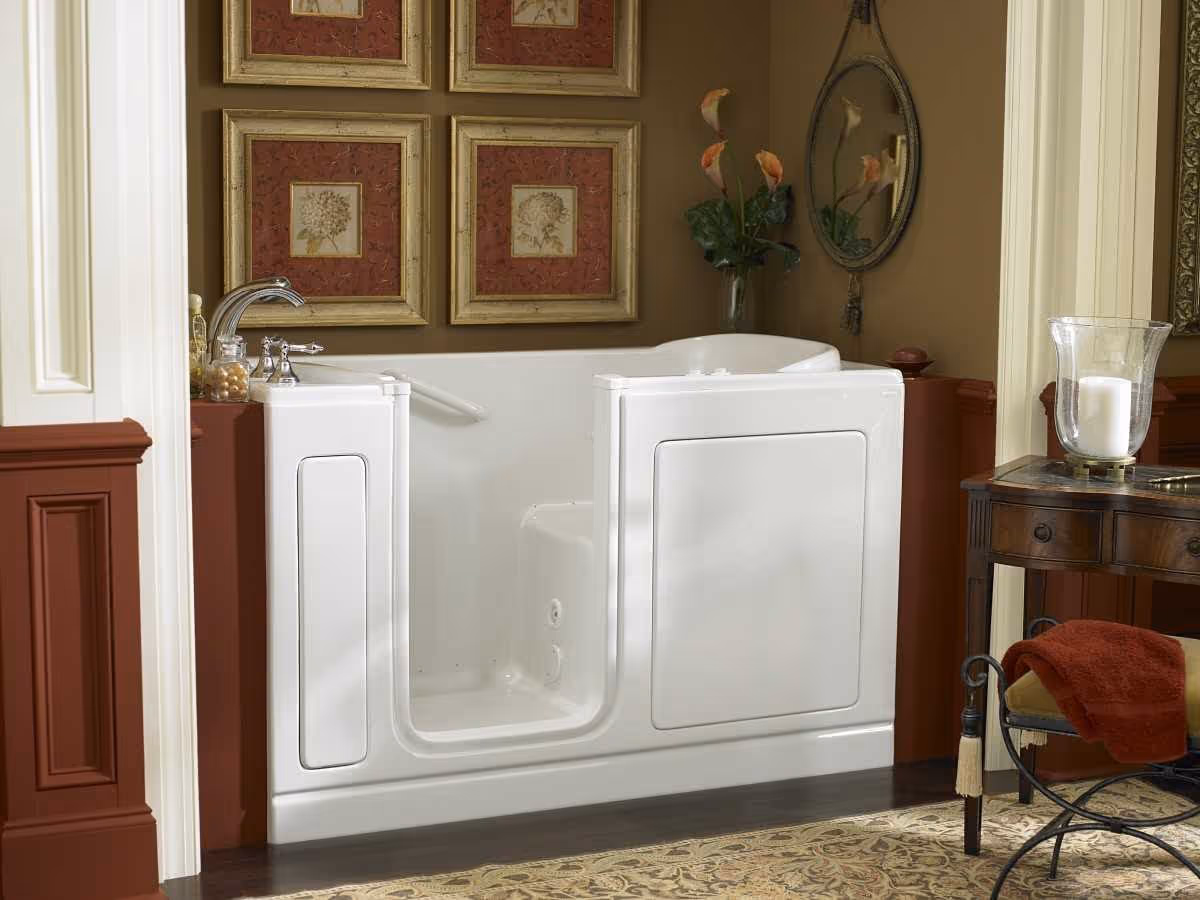 Interior bathroom featuring a white walk-in tub, sink, and framed wall art.