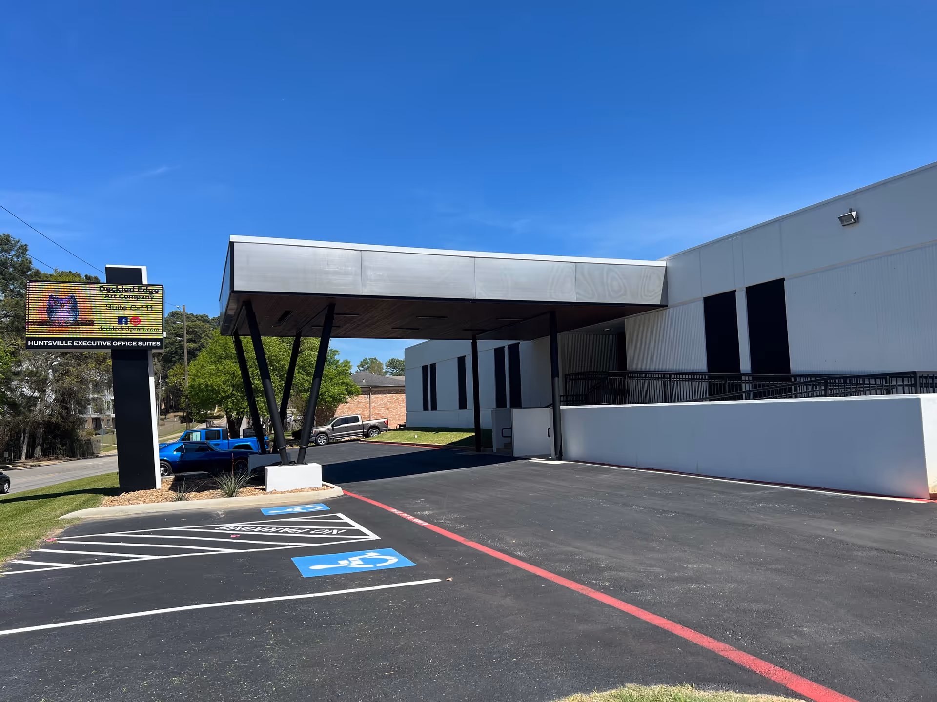 Front exterior of a modern facility with a canopy entrance and handicapped parking