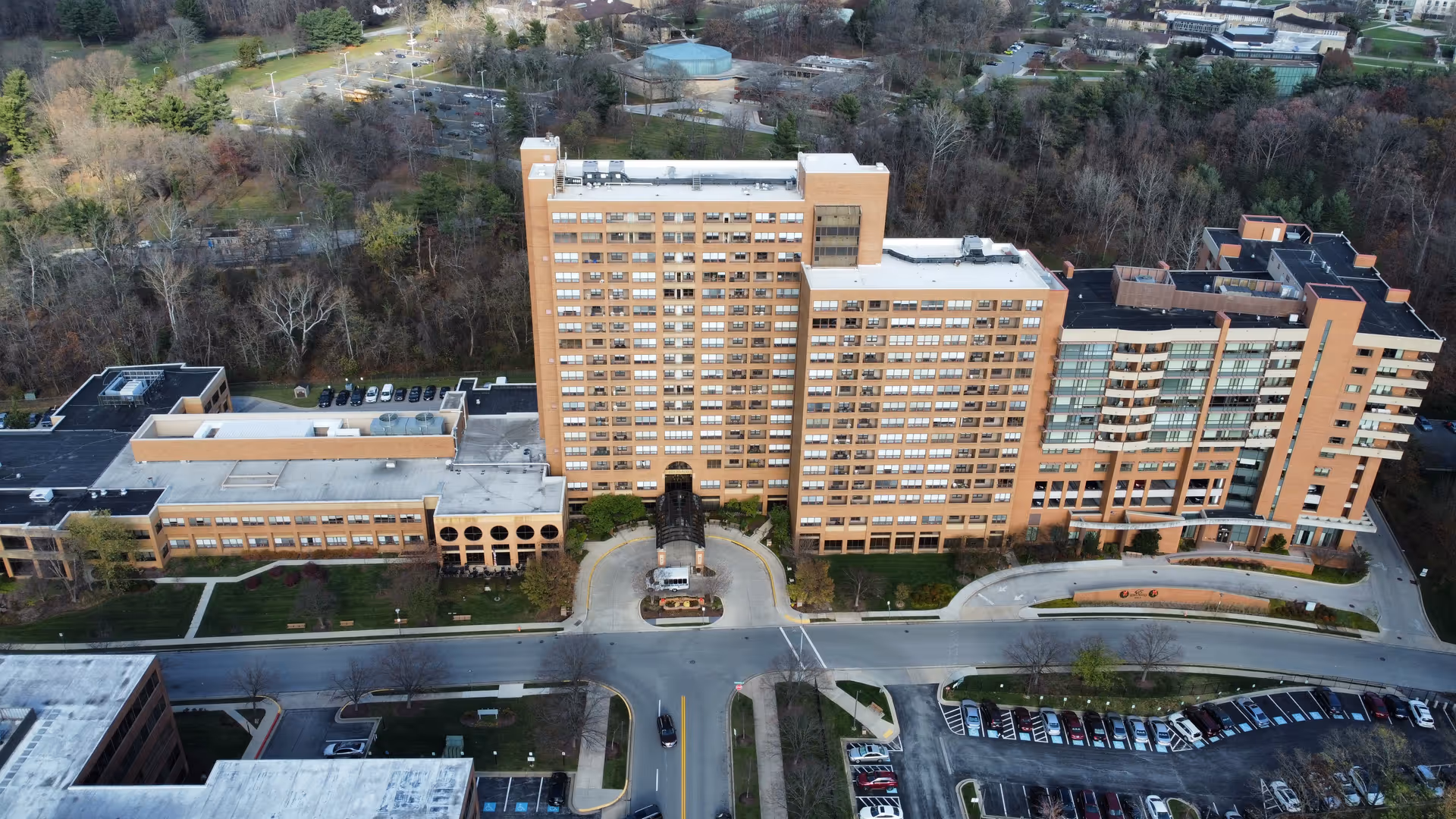 Aerial view of Edenwald Senior Living brick building with curved driveway and surrounding parking.