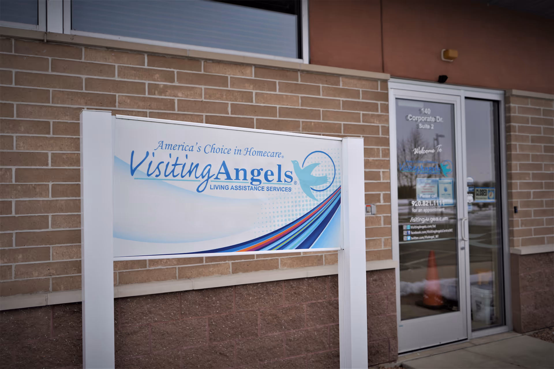 Exterior of Visiting Angels Beaver Dam facility with sign and glass entrance.