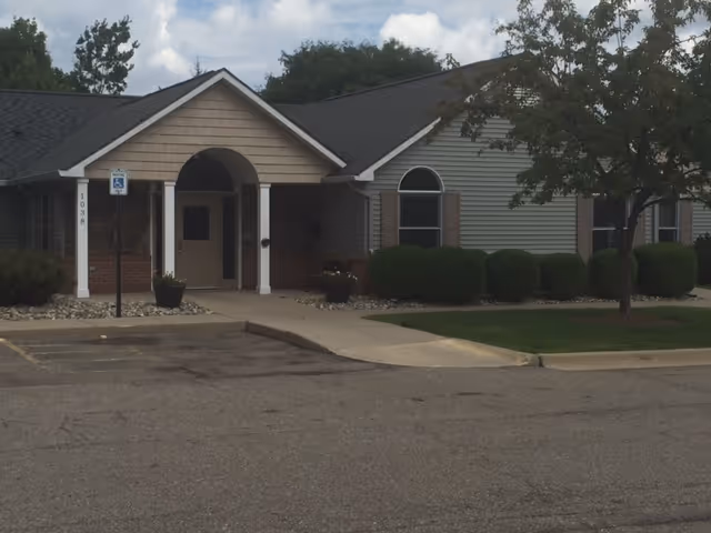Front entrance of LoveJoy Community Services senior living facility with shrubs and parking.