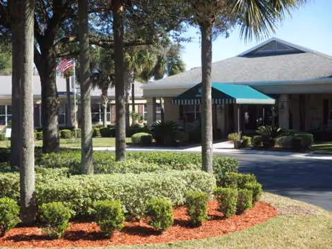 Facade of Pacifica Senior Living Ocala with entrance, green awning, and landscaped front.