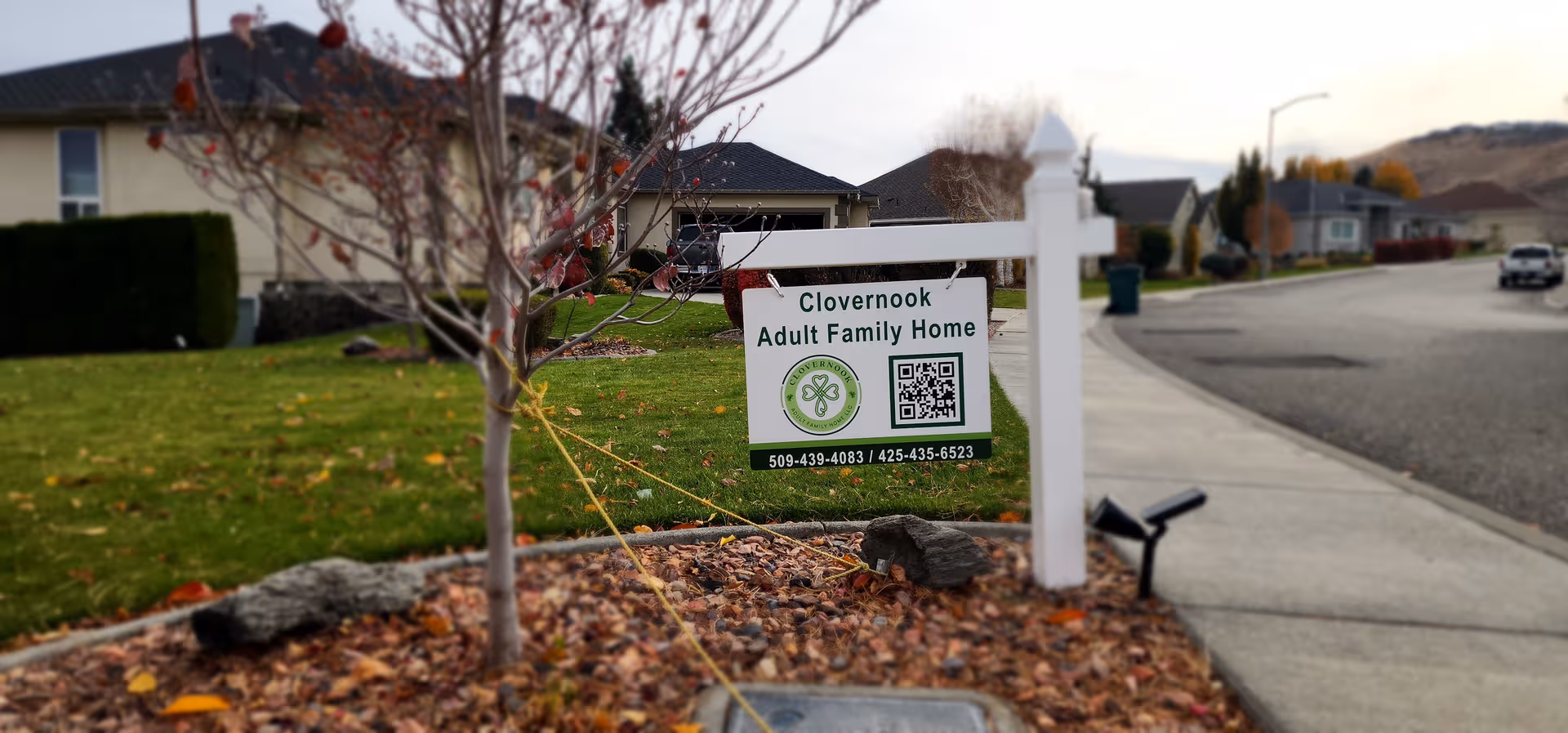 Residential street view featuring Clovernook Adult Family Home sign in front yard.
