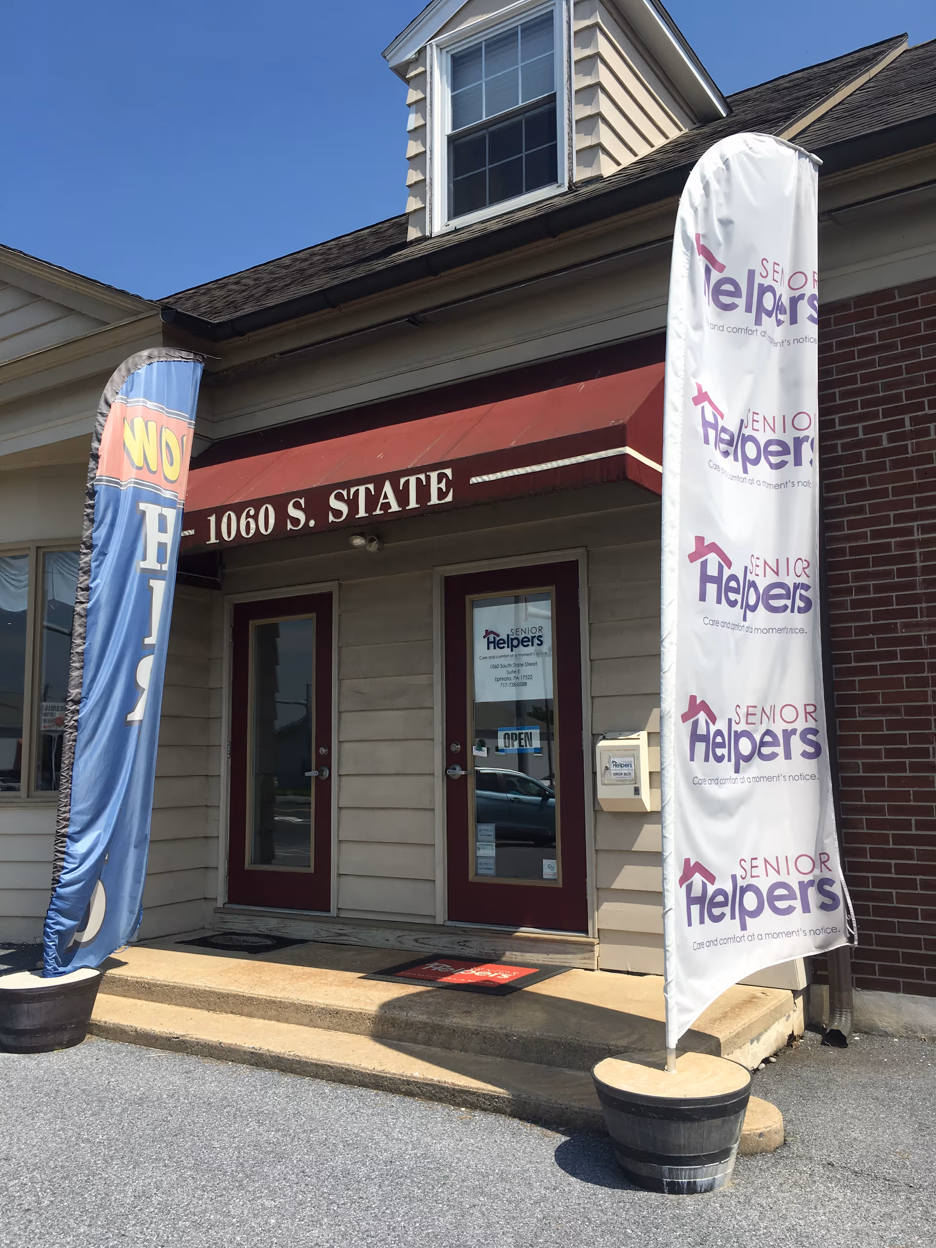 Exterior view of Senior Helpers of Lancaster County building with banners and two doors.
