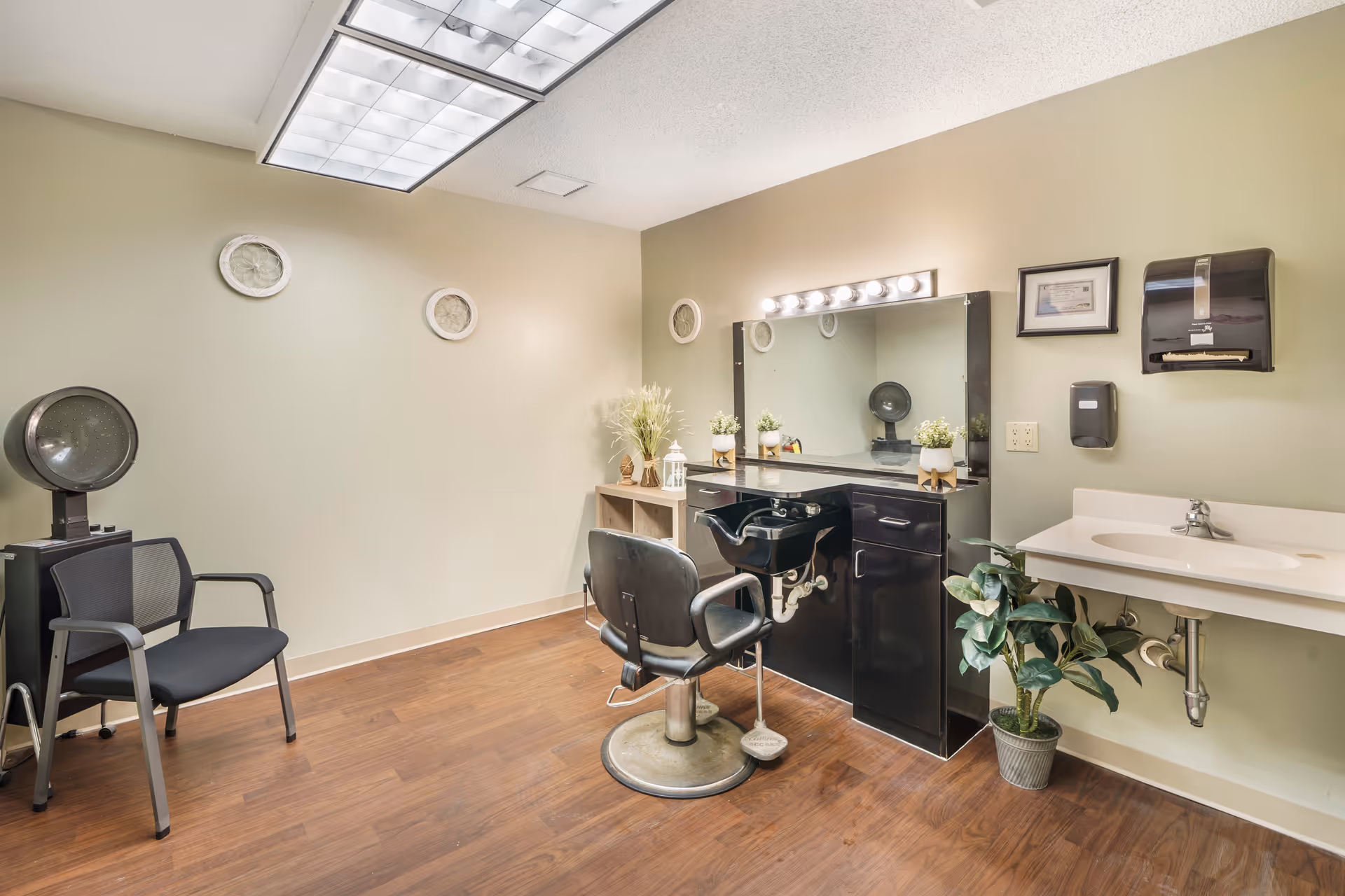 Senior living facility hair salon with mirrors, chairs, and a sink in a tidy room.