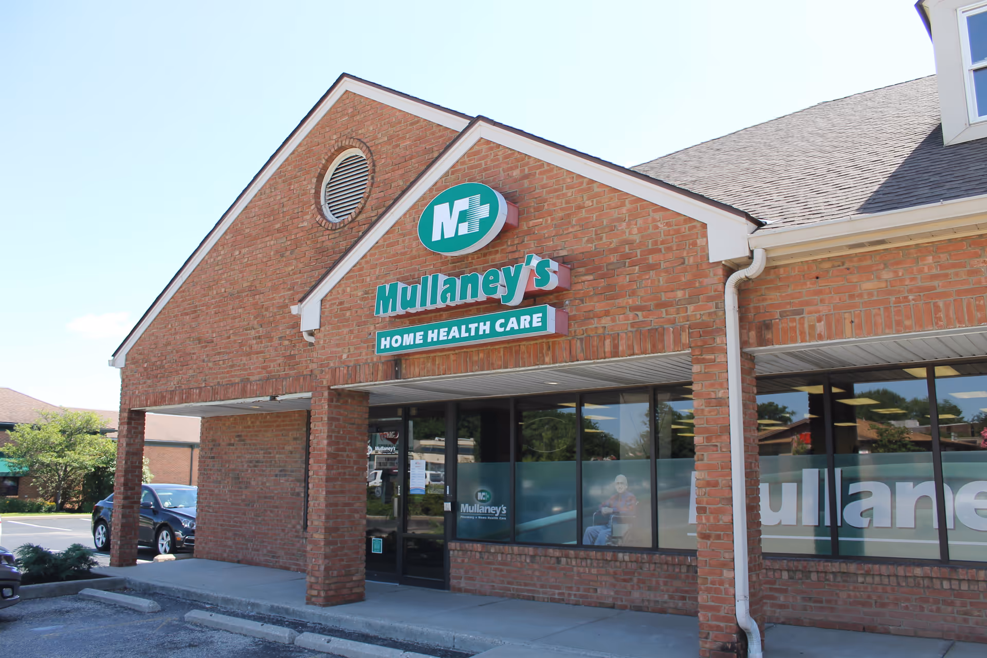 Brick storefront with Mullaney's Home Health Care sign and large front windows.