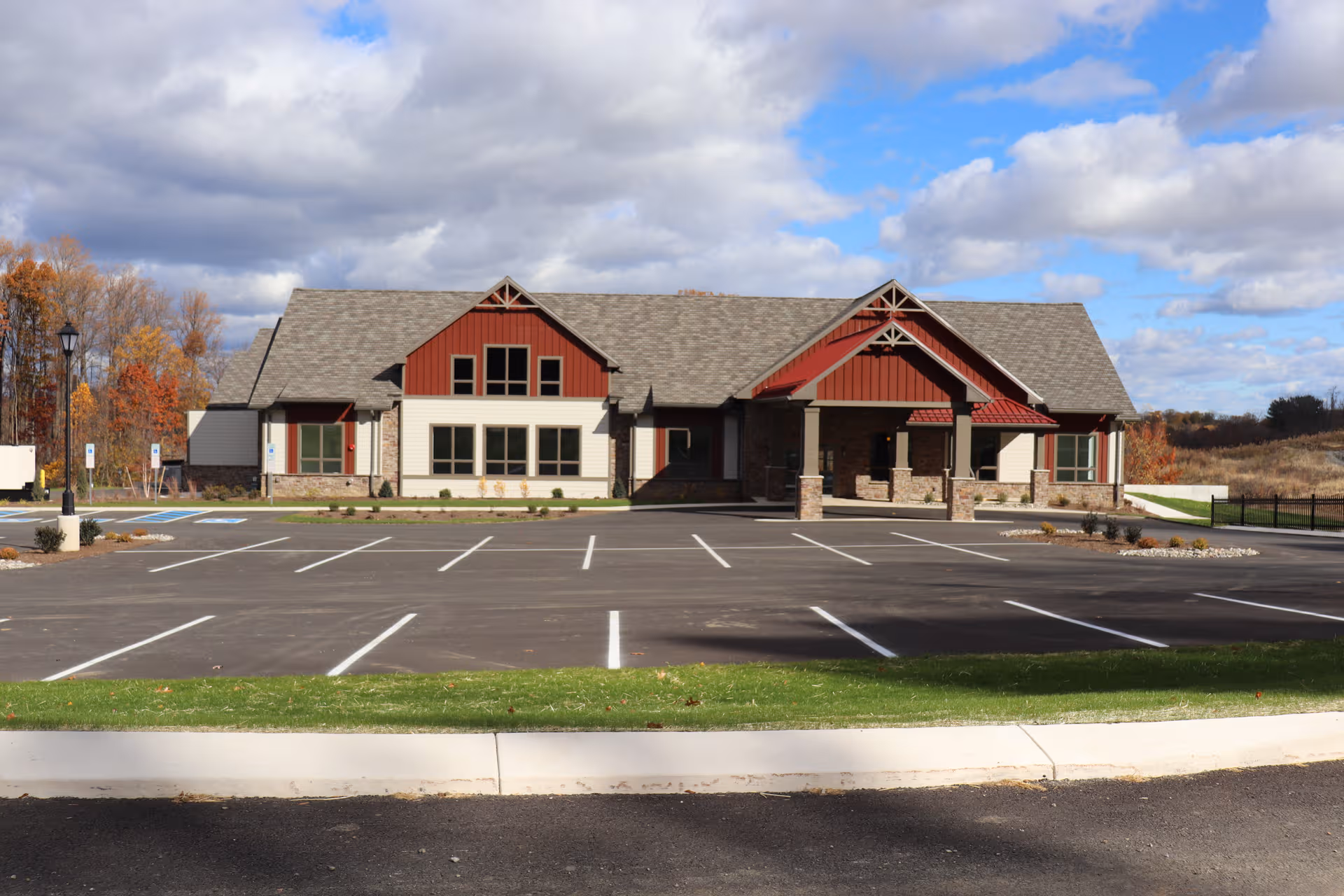 Exterior view of Cornwall Manor senior living building with a large parking lot.