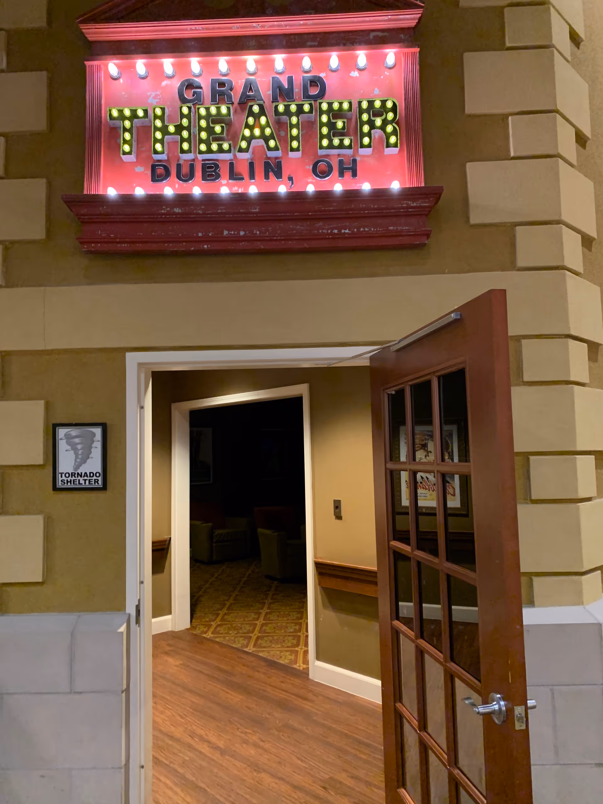 Lit theater sign above an open doorway into a lobby at The Grand.