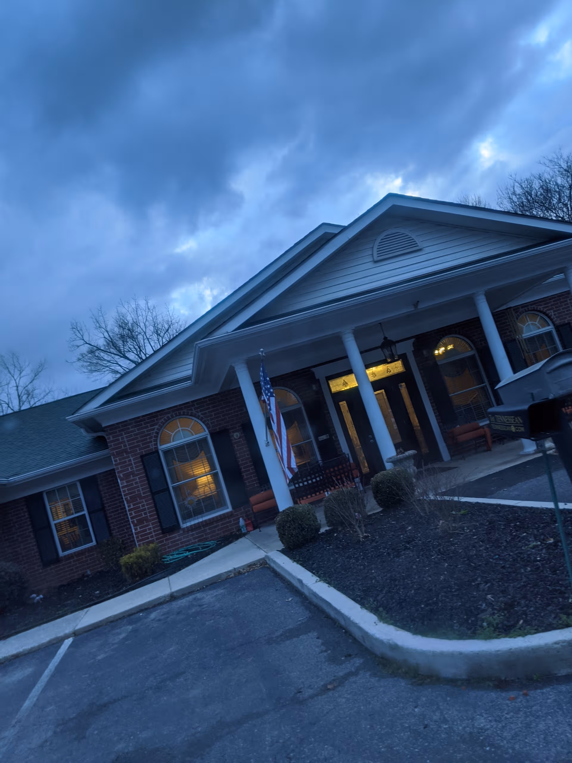 Riverview Terrace front entrance of a brick senior living facility with columns.
