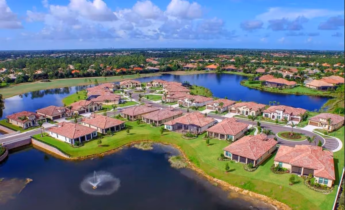Aerial view of Stillwater Health Care campus with red-roofed buildings around a lake and fountain.