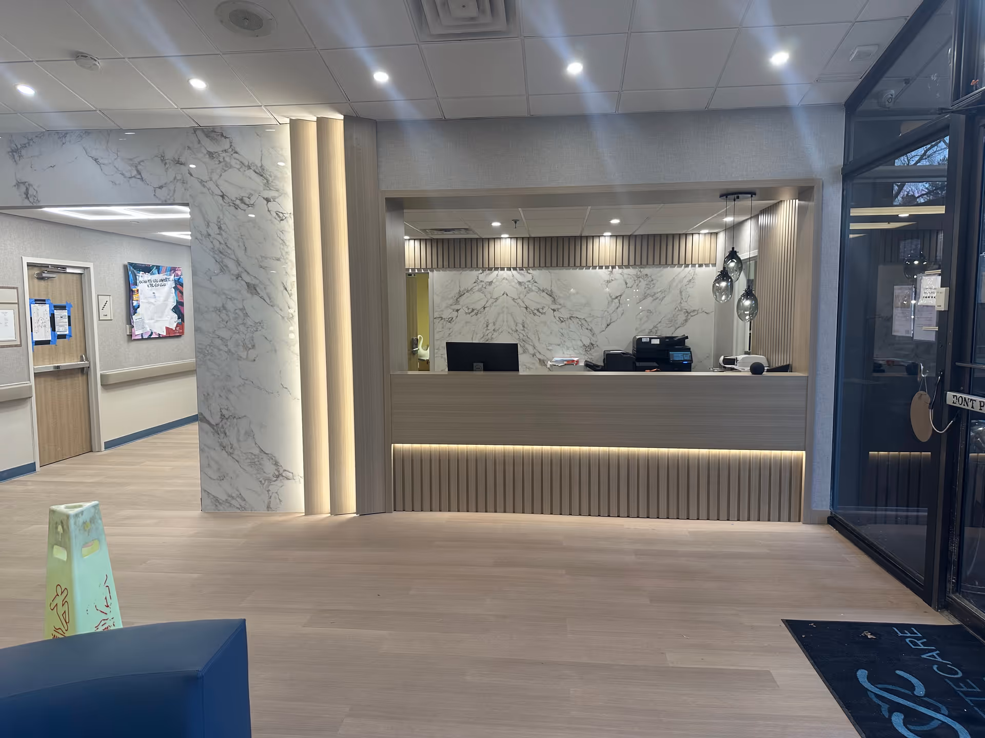 Modern facility lobby with marble walls, reception desk, and glass entry doors.