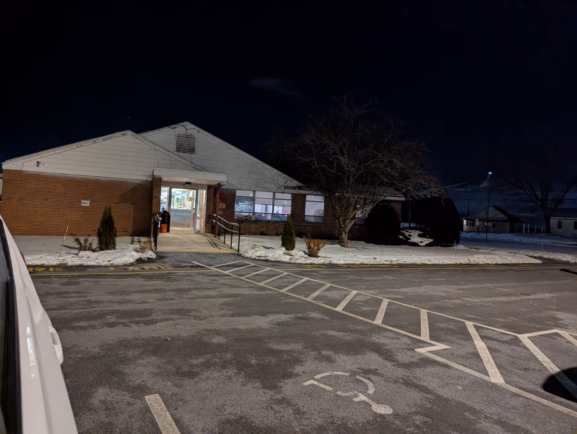 Night exterior of Chicopee Rehabilitation and Nursing Center entrance with parking lot