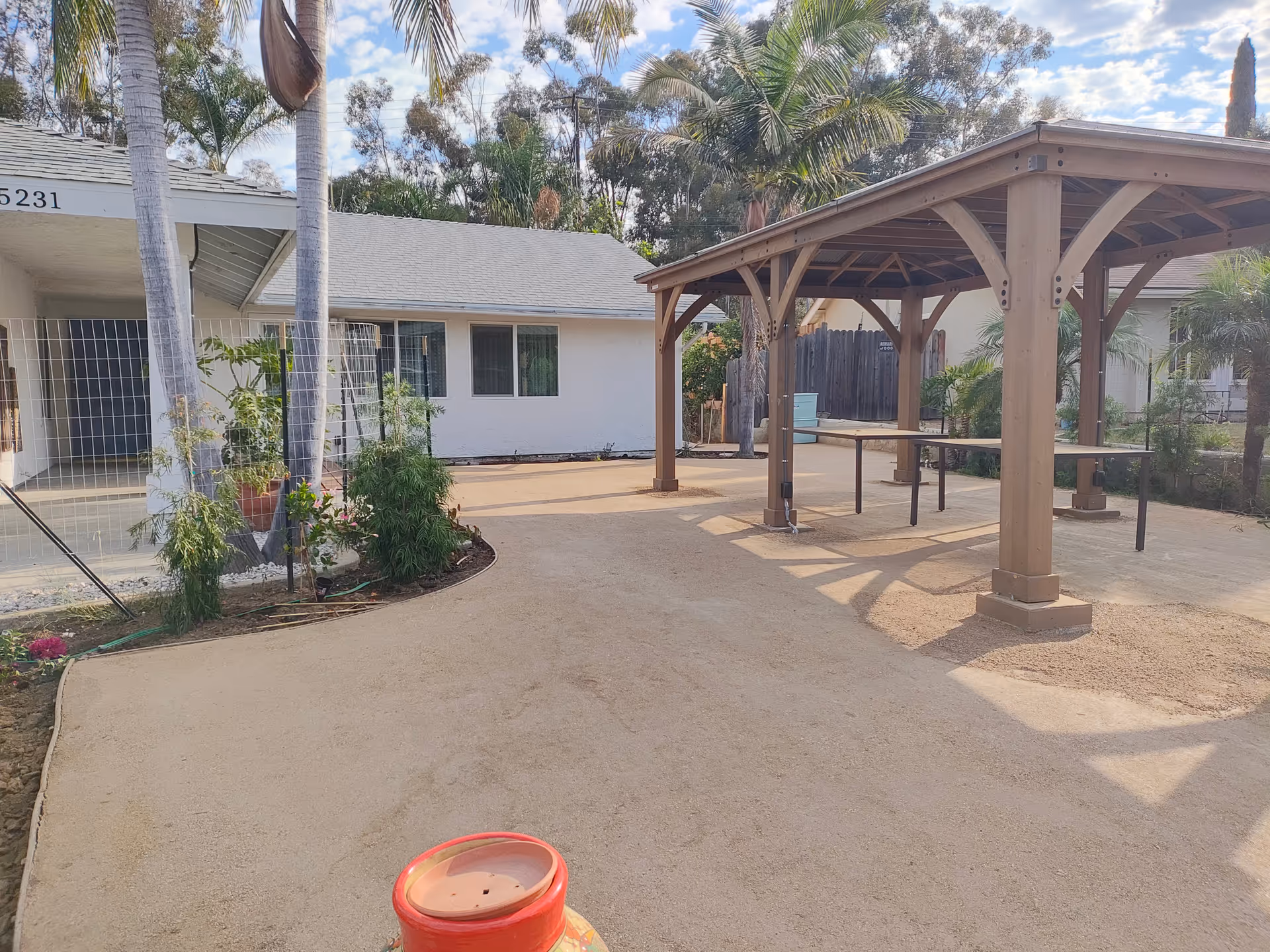 Exterior view of Golden Hearts Elderly Care 2 with an outdoor pavilion and palm trees.