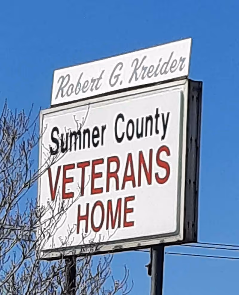 Outdoor sign reading 'Sumner County Veterans Home' against a clear blue sky.