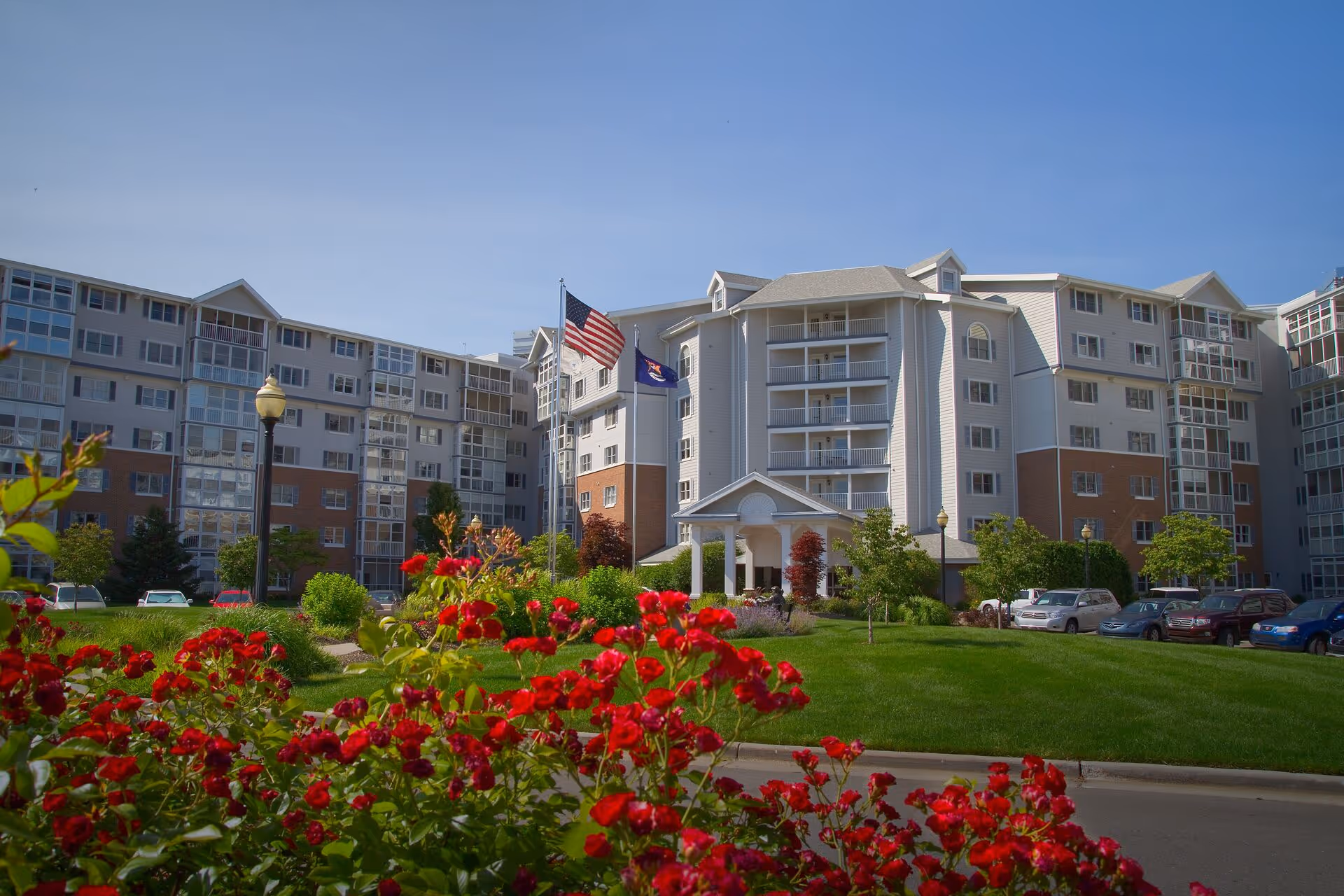 Front view of The Inn at Freedom Village, a multi-story senior living building with landscaped lawn.