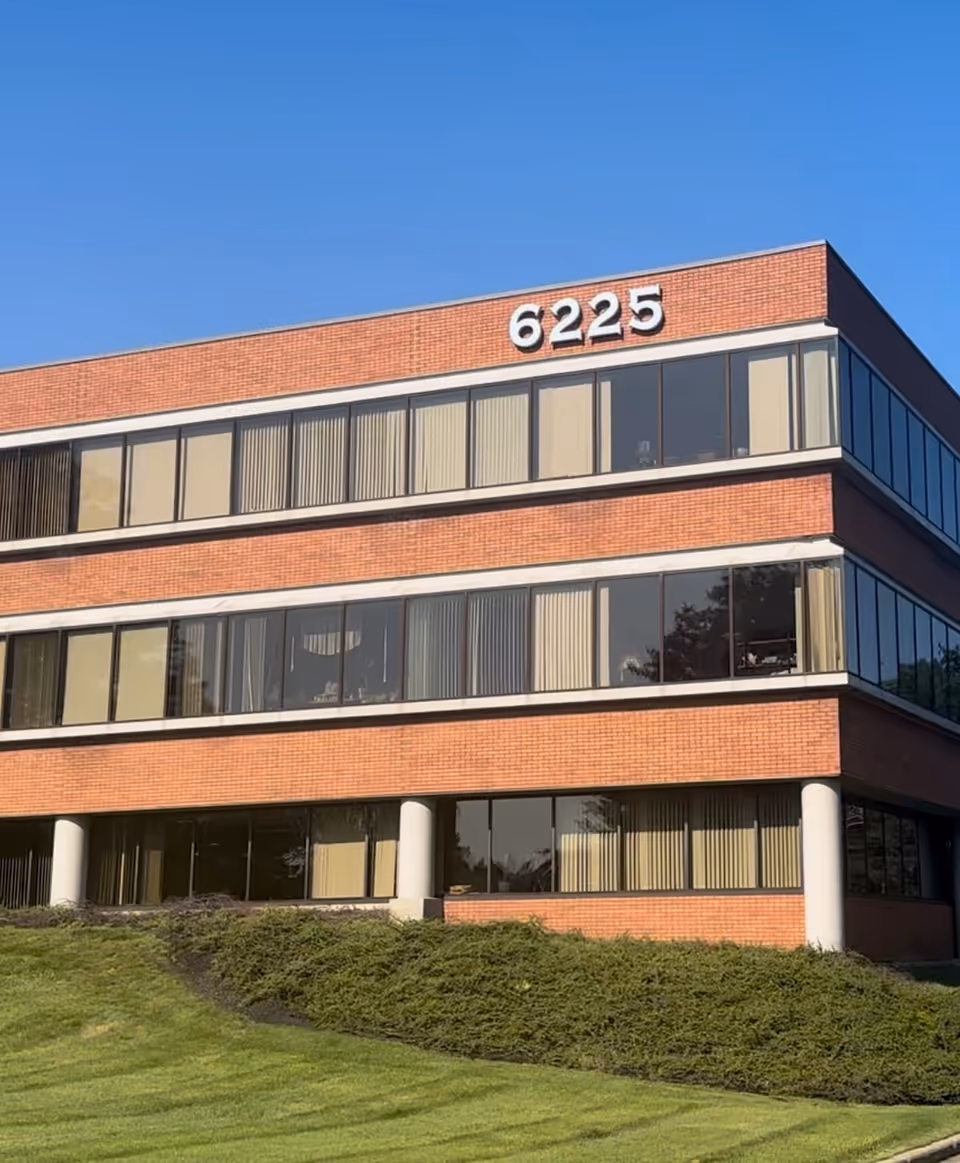 Exterior of a brick office building with large windows and the number 6225.