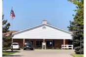 Front view of Medilodge of Sterling building with cars parked in driveway.