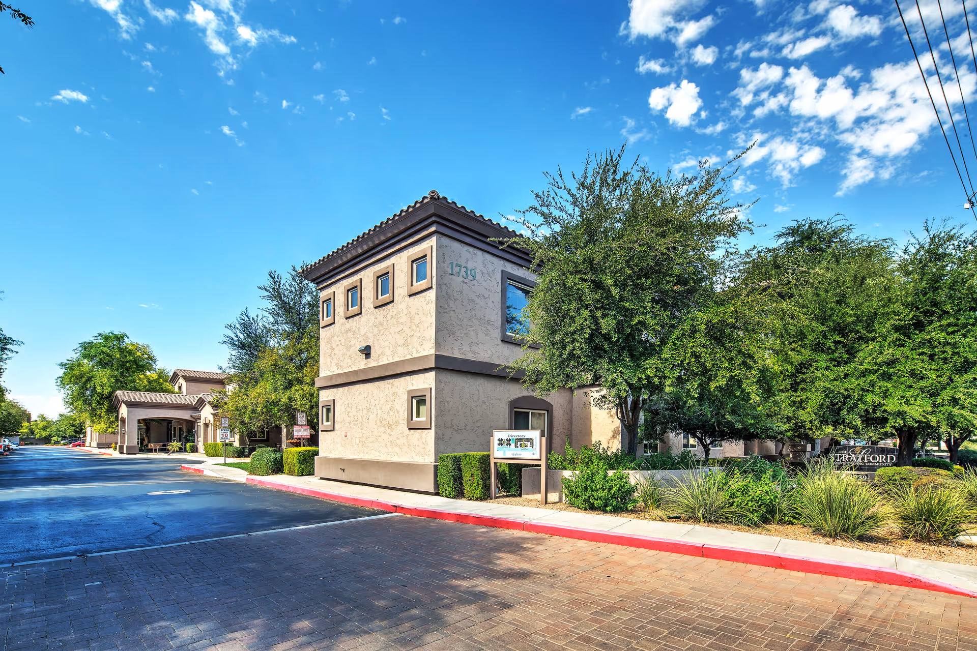 Exterior view of Ridge at the Stratford building with landscaping and a driveway.