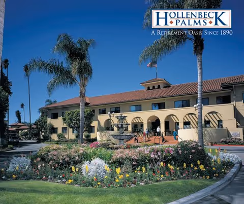 Exterior view of Hollenbeck Palms retirement facility with palm trees and colorful garden.