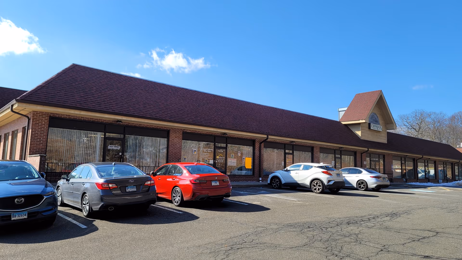 Single story strip mall type building labeled Faithful Essence Home Care with parked cars in front
