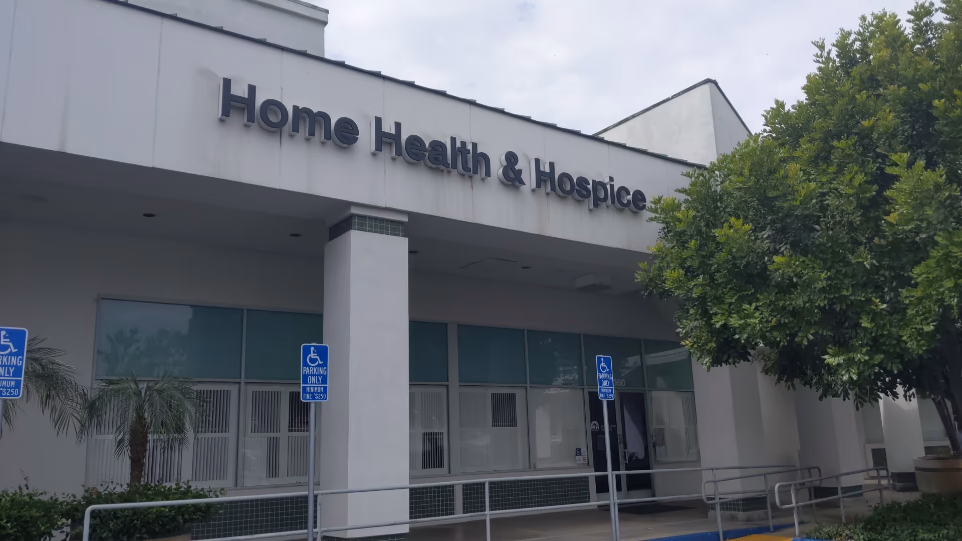 Front exterior of a Home Health & Hospice facility with entrance and handicap parking signs